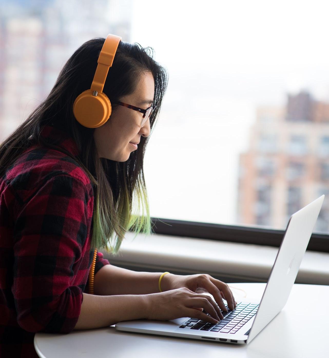 shallow focus photo of woman using gray laptop computer