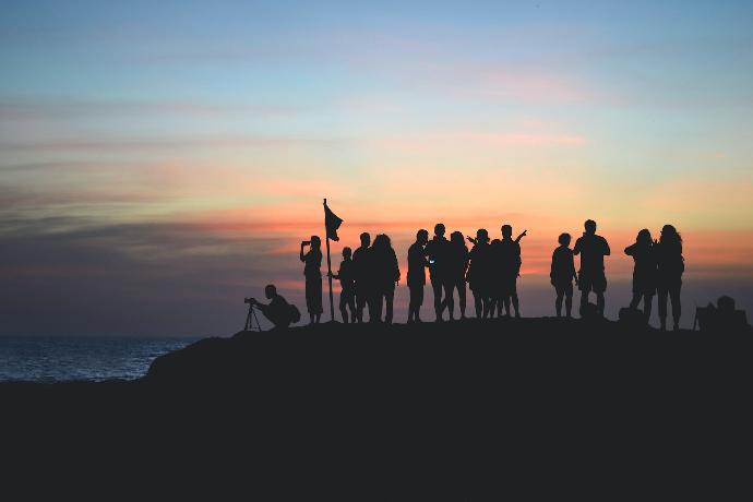 silhouette photography of people gathered together on cliff